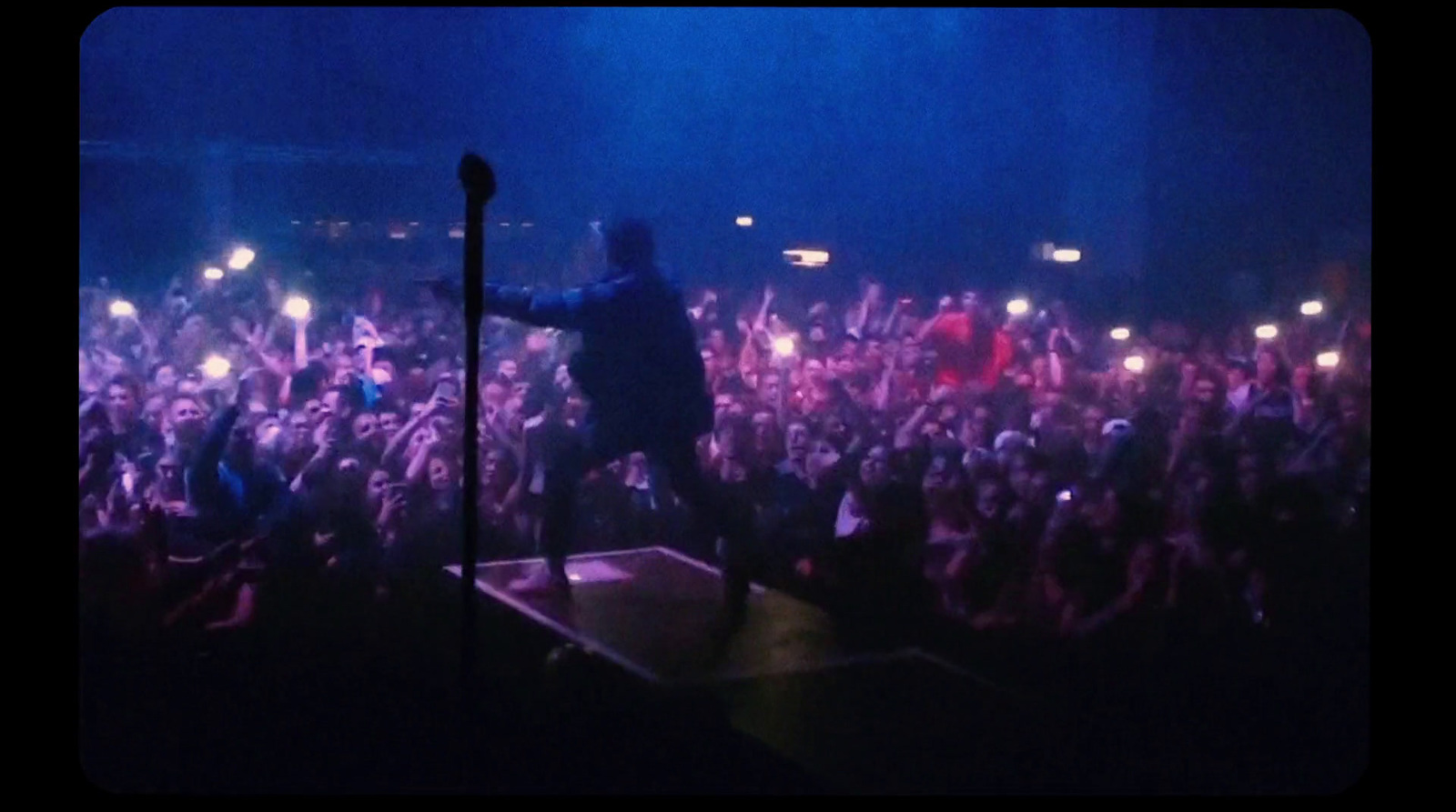 a man standing on top of a stage in front of a crowd