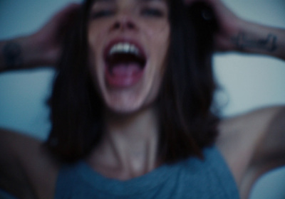 a woman with her hands on her head screaming