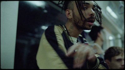 a man with dreadlocks standing on a subway