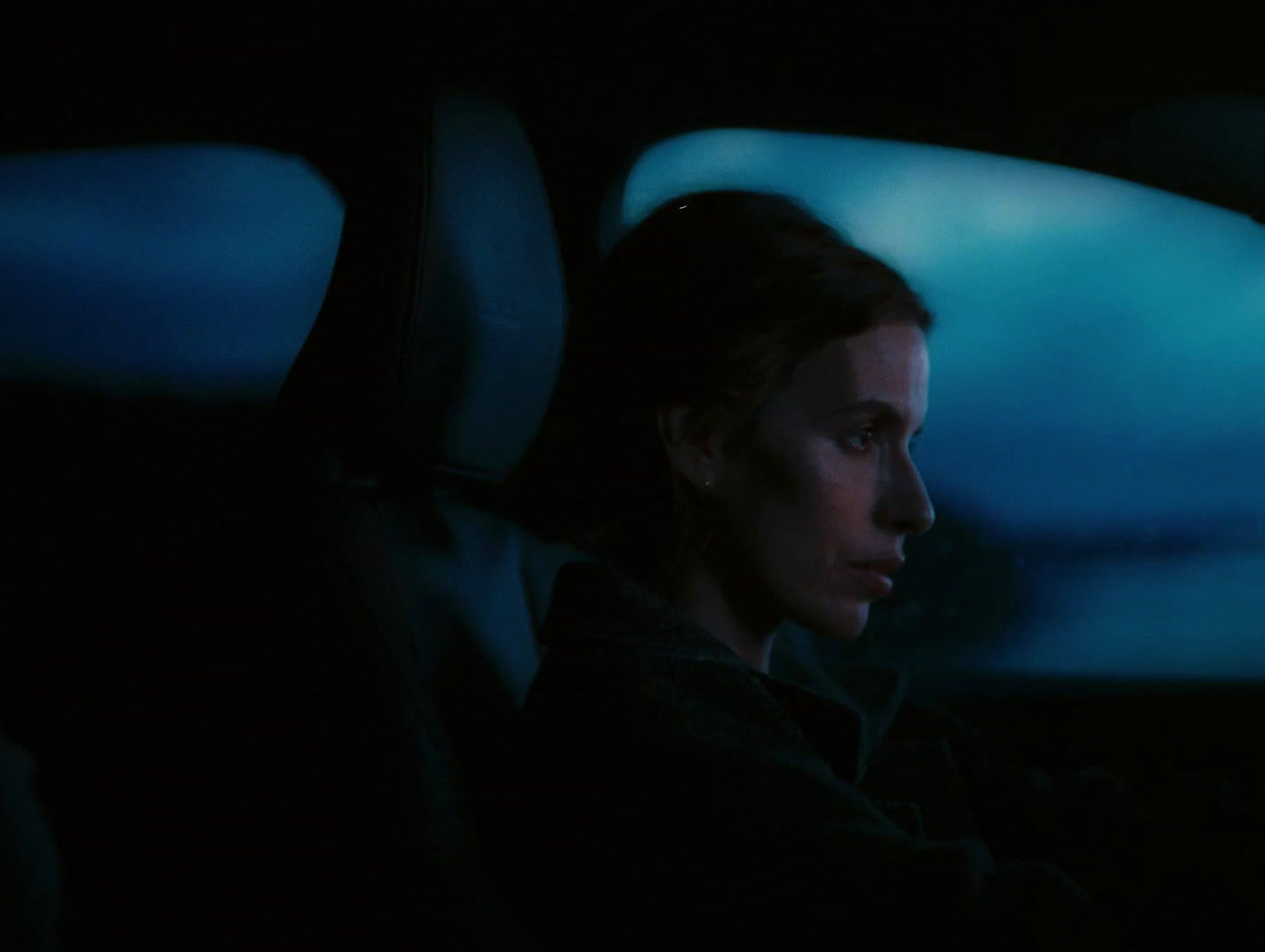 a woman driving a car in the dark