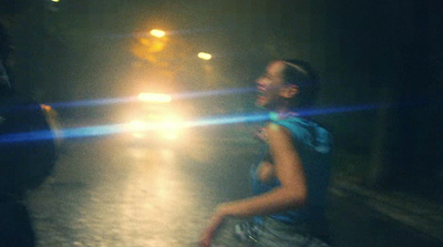 a woman walking down a street at night