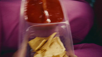 a person holding a container of food with chips and ketchup