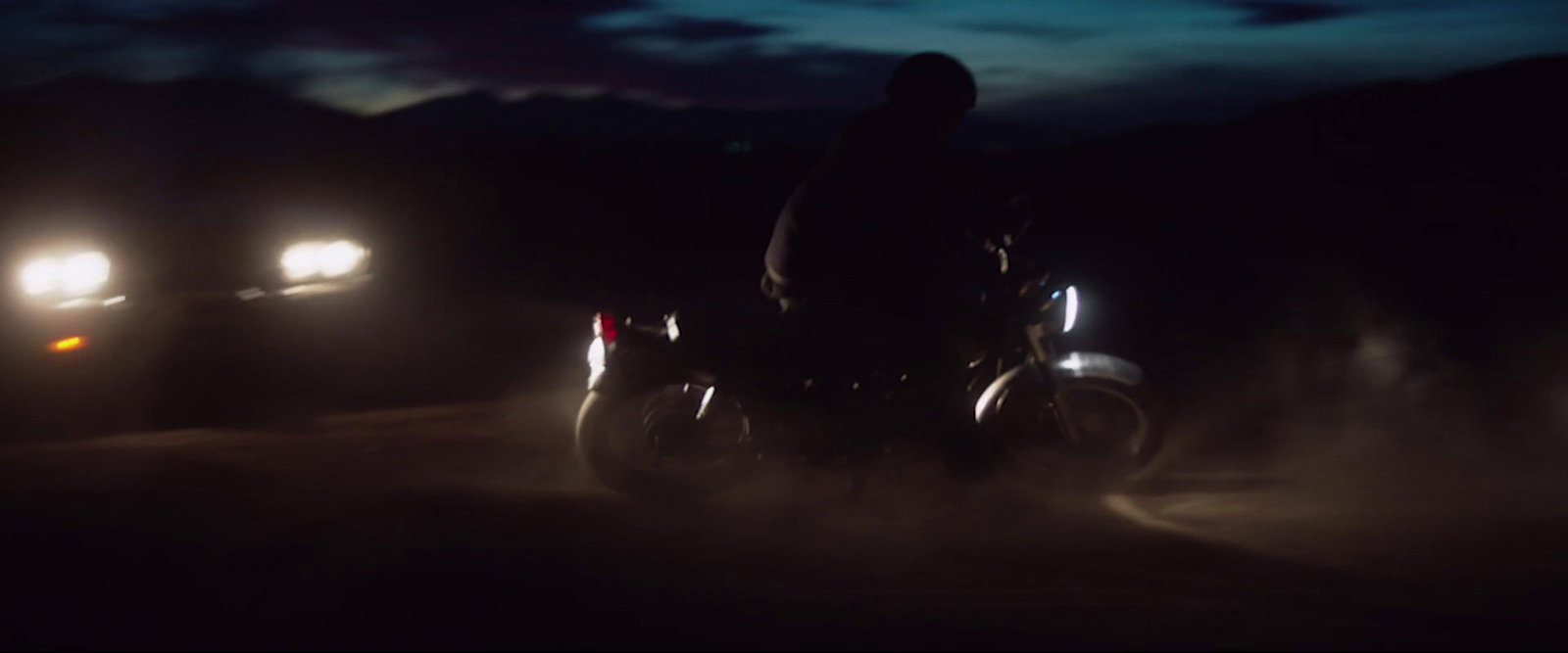 a person riding a motorcycle in the dark