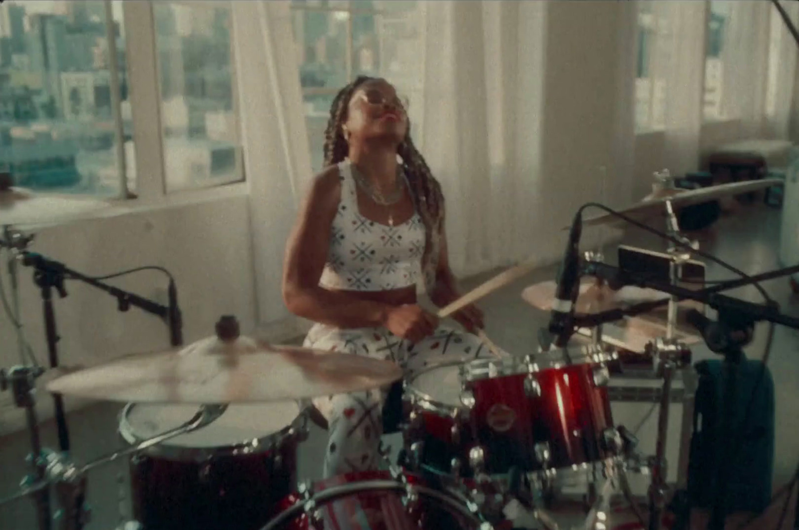 a woman sitting in front of a drum set