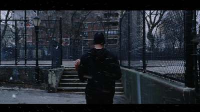 a man standing in front of a fence in the snow