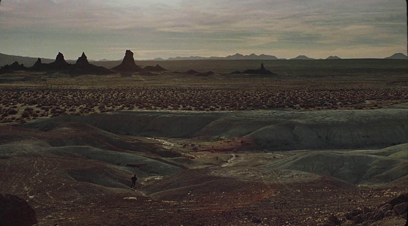 a man riding a horse through a desert landscape