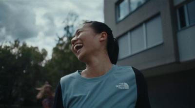 a woman laughing in front of a building