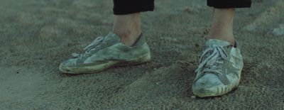 a person standing in the sand with their shoes on