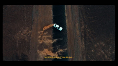 an aerial view of a car driving down a dirt road