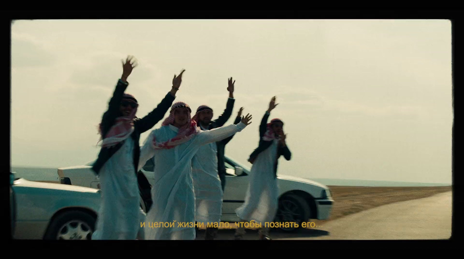 a group of people standing next to a white car