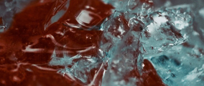 a close up of ice and water with a red background