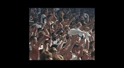 a crowd of people standing around a man on a skateboard