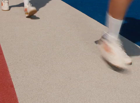 a close up of a person walking on a tennis court