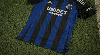 a blue and black soccer jersey laying on the ground