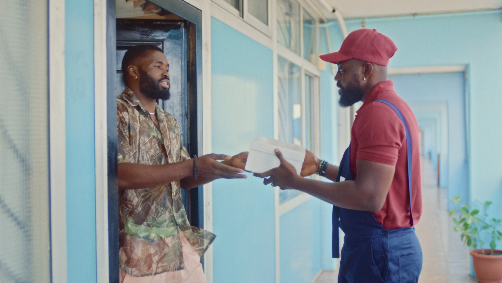 a man handing another man something out of a window