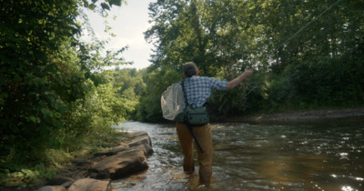 a man standing in a river holding a fish net