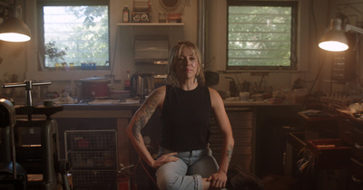 a woman sitting on a chair in a kitchen