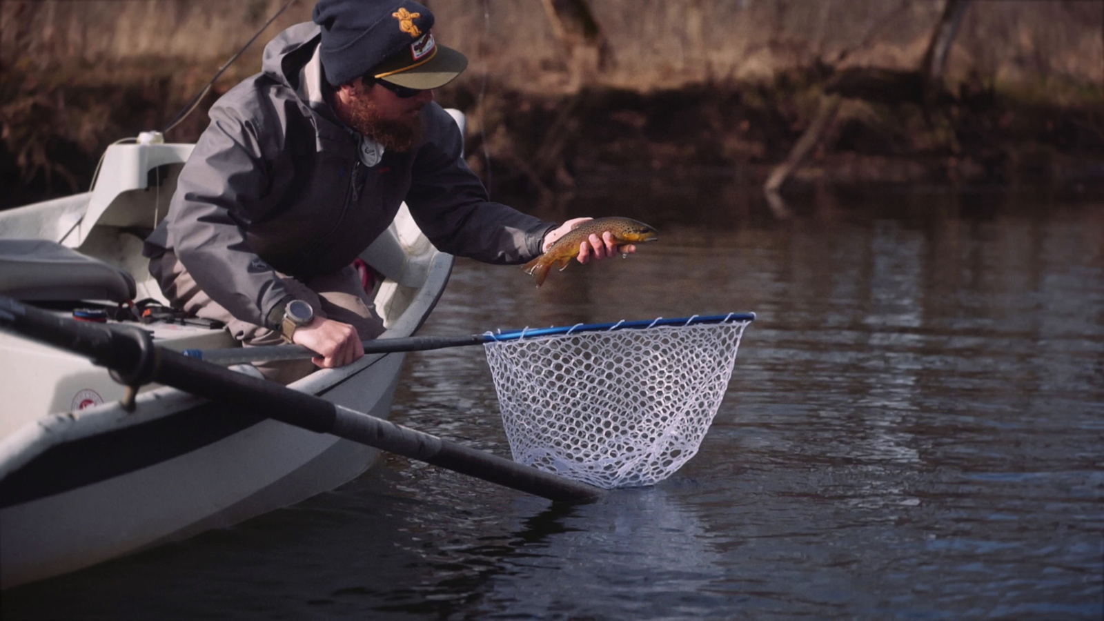 a man in a boat catching a fish with a net