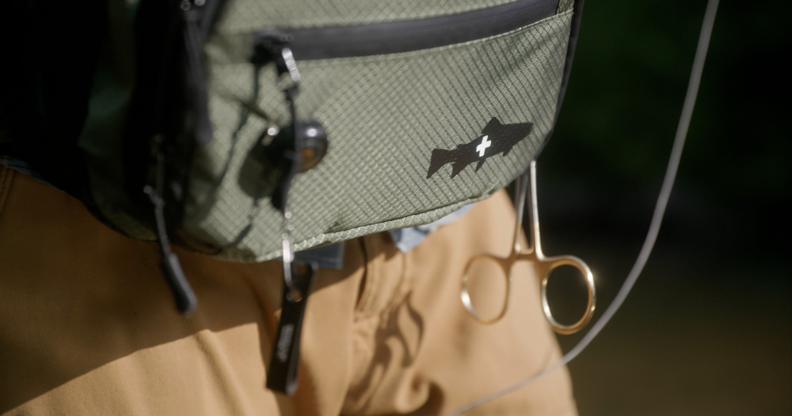 a pair of scissors hanging from the back of a backpack