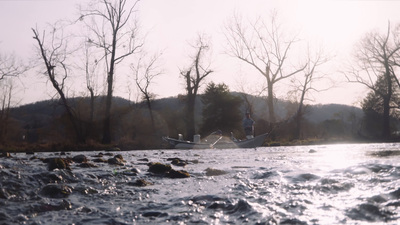 a man standing on a boat in a river