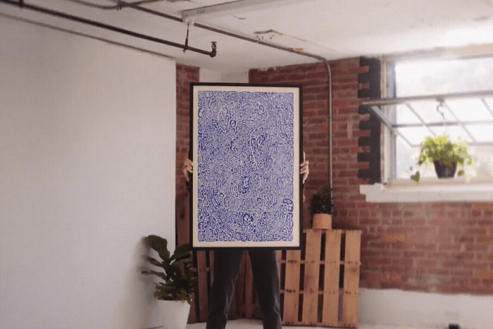 a person holding a large blue painting in a room