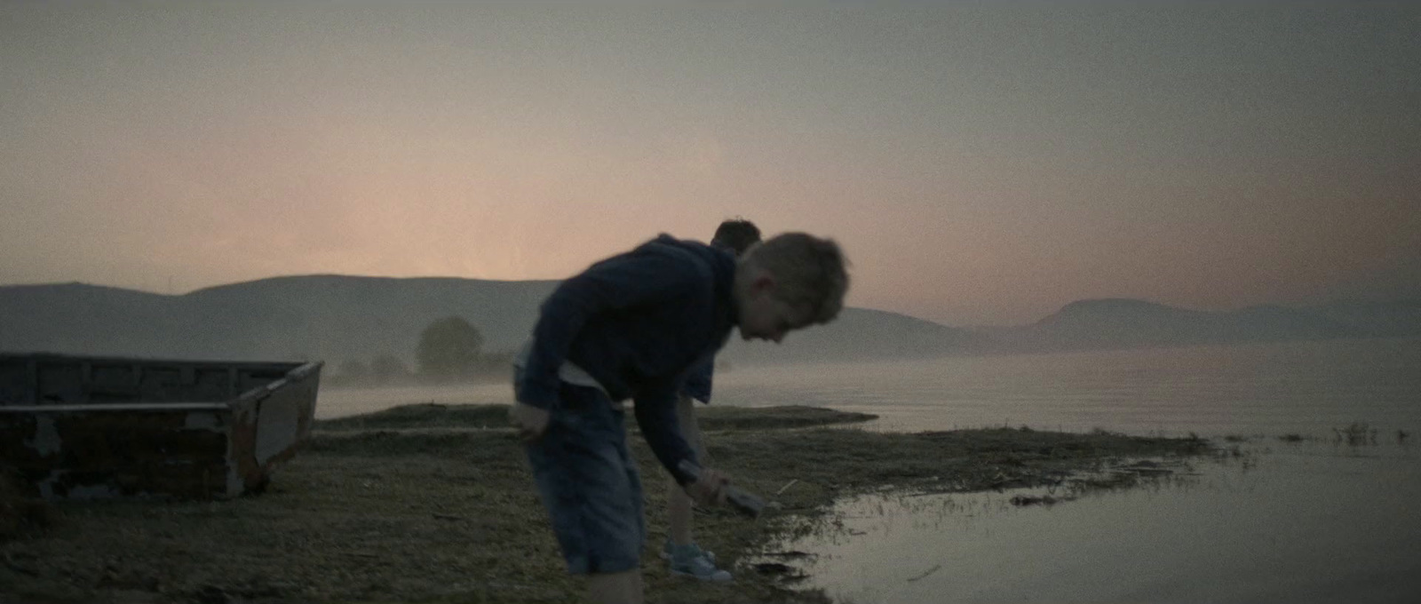 a man standing next to a body of water