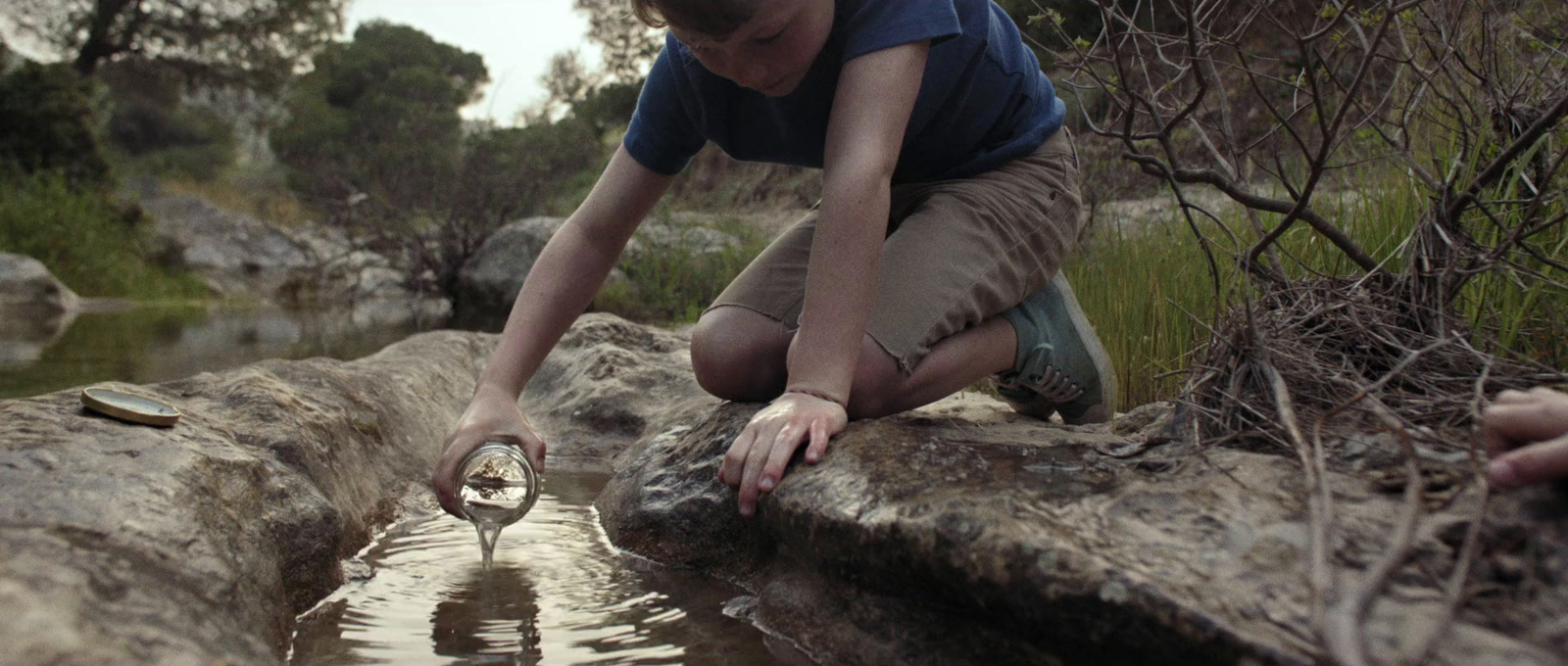 a boy is playing with a bottle in the water