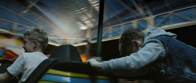 two young men riding on a ride at a carnival