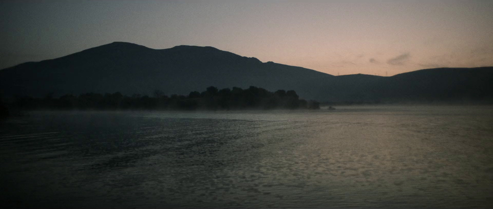 a body of water with mountains in the background