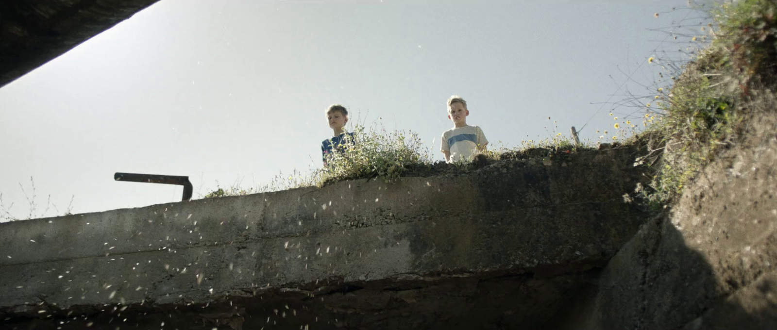 a couple of people standing on top of a cement wall