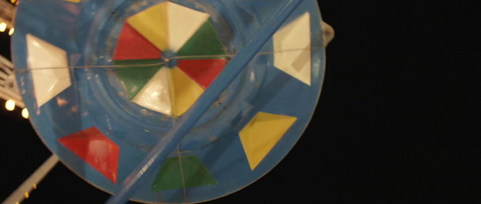 a close up of a colorful kite on a pole