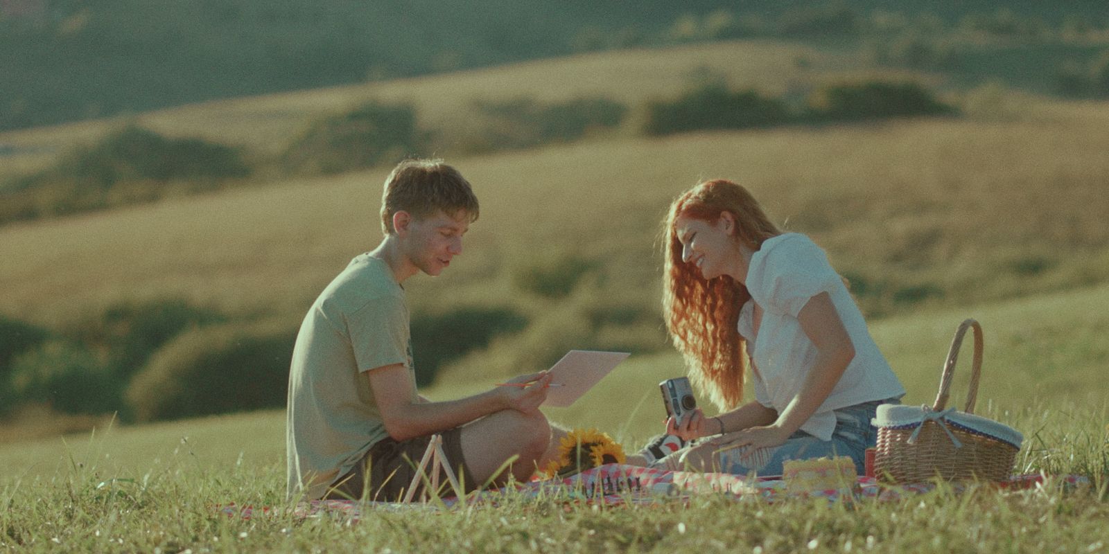 a man and a woman sitting in a field