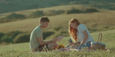 a man and a woman sitting in a field