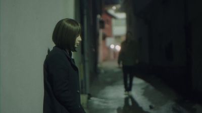 a woman standing next to a wall in a hallway