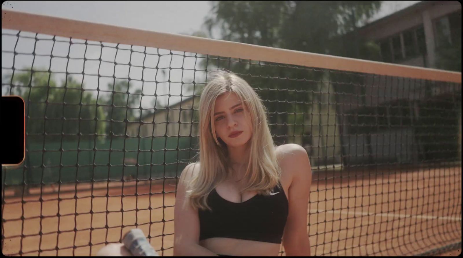 a woman standing in front of a tennis net