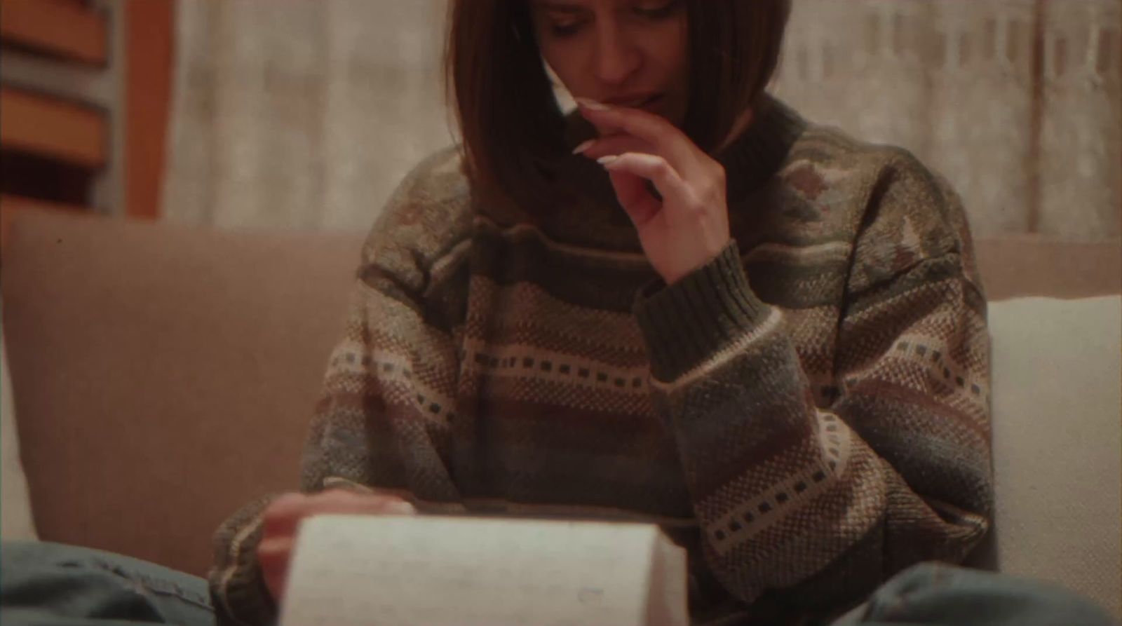 a woman sitting on a couch smoking a cigarette