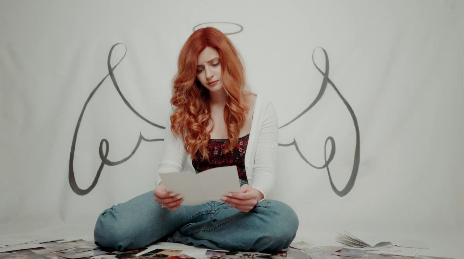 a woman sitting on the floor with a sheet of paper in front of her