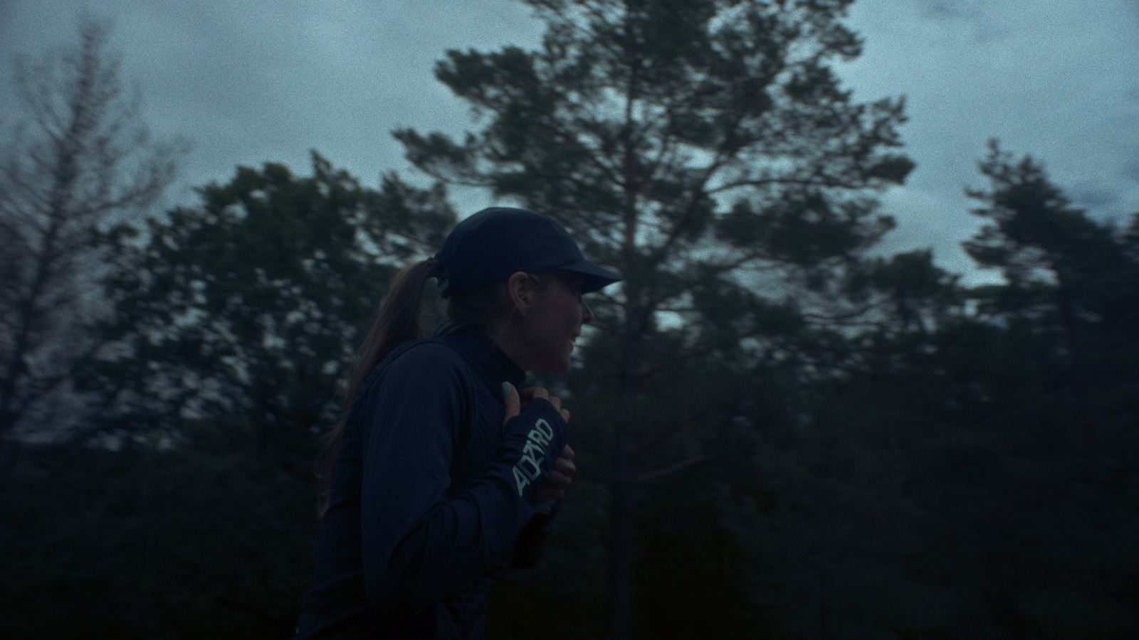 a woman standing in front of a forest at night