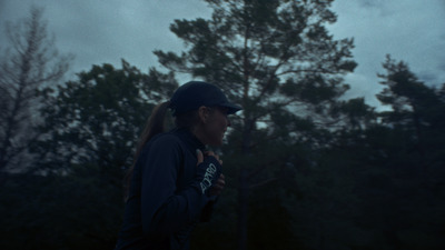 a woman standing in front of a forest at night