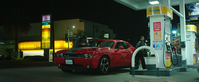 a red car at a gas station at night