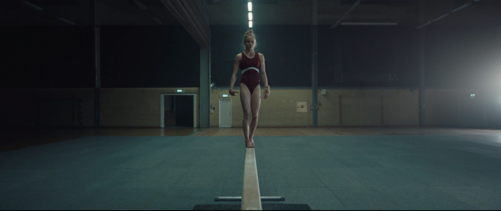 a woman standing on a beam in a building