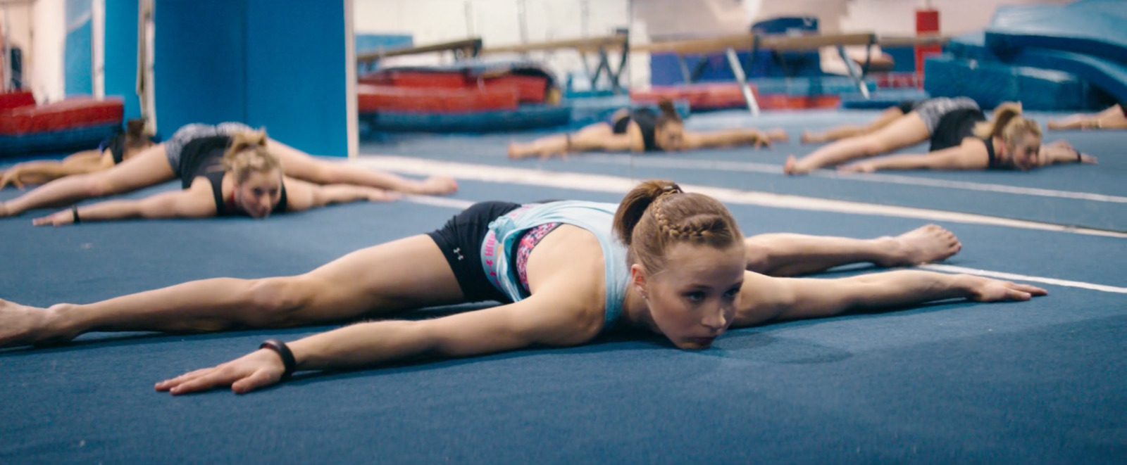 a group of women laying on top of a blue floor