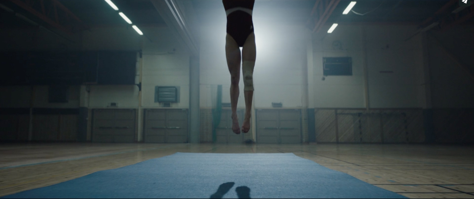 a person jumping in the air on a blue mat