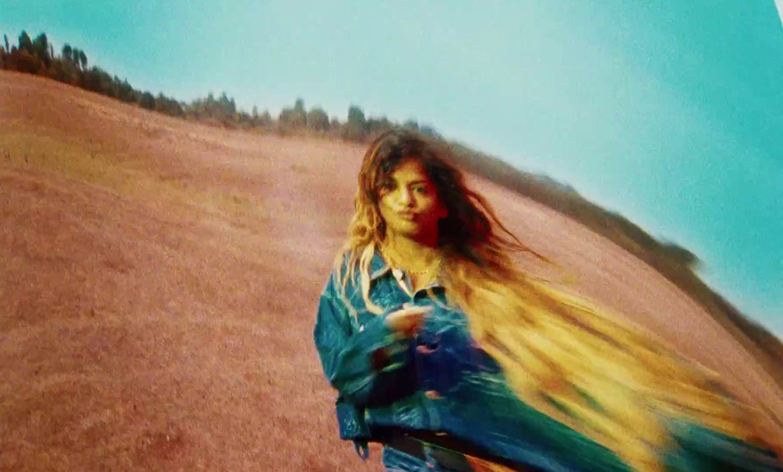 a woman in a blue jacket holding a yellow frisbee