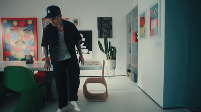 a man standing in a room next to a green chair