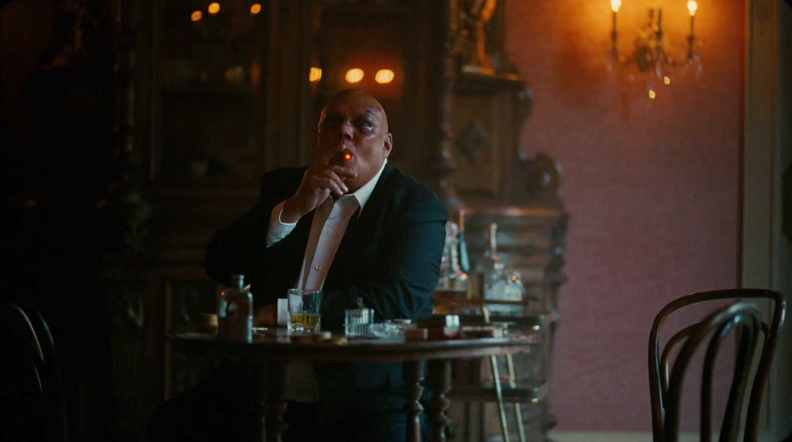 a man sitting at a table smoking a cigarette