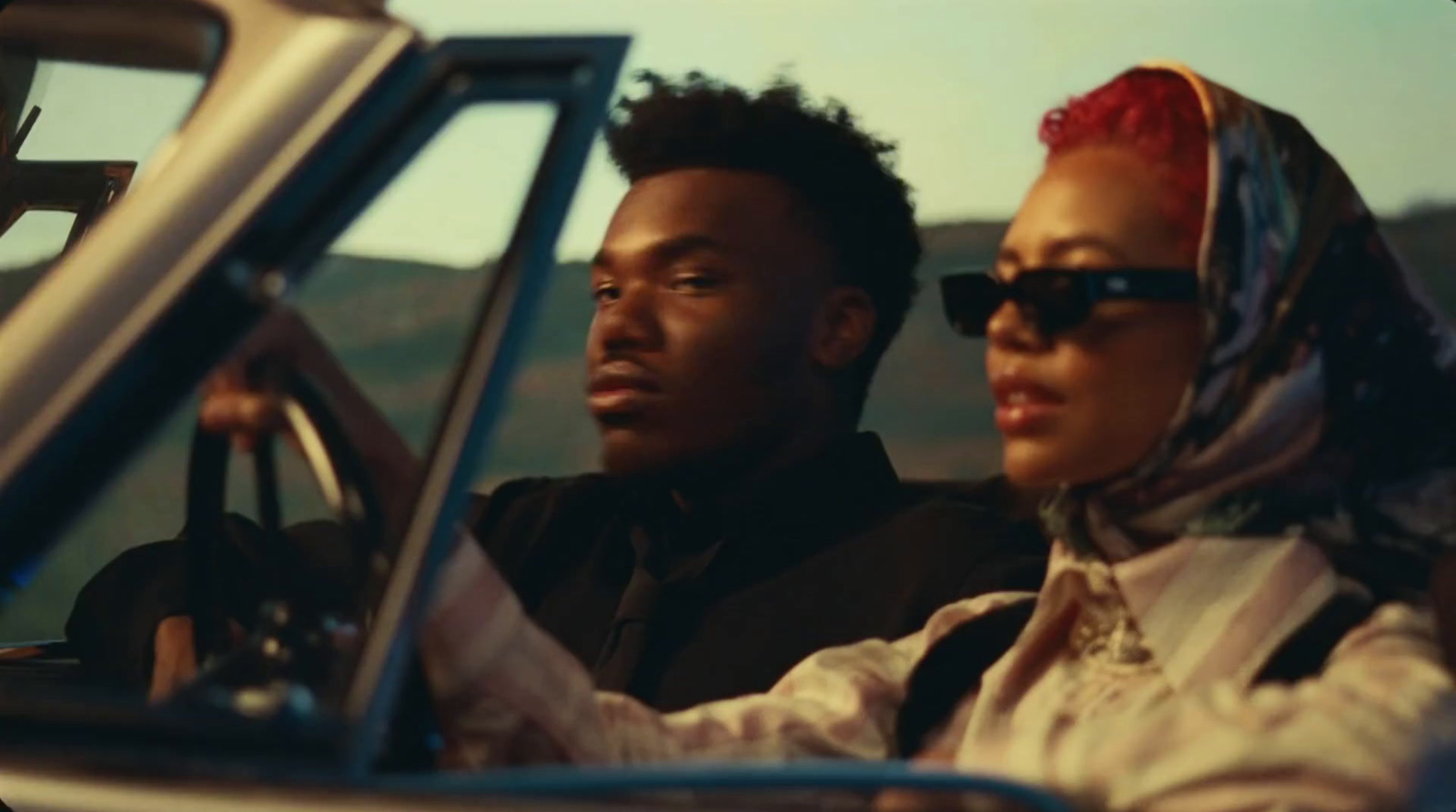 a man and a woman sitting in a car