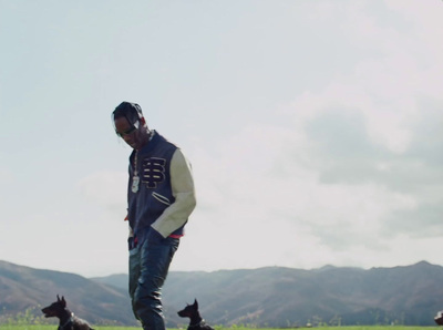 a man standing in a field with three dogs