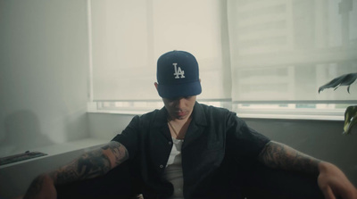 a man wearing a hat sitting in front of a window