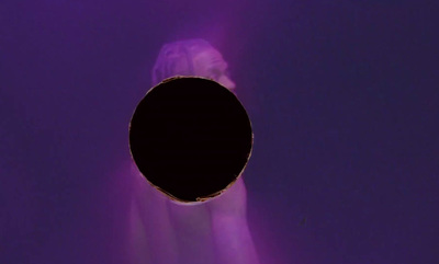 a black hole in the middle of a purple wall